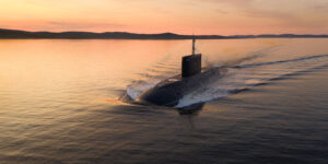 Submarine gliding through the water at sunset.