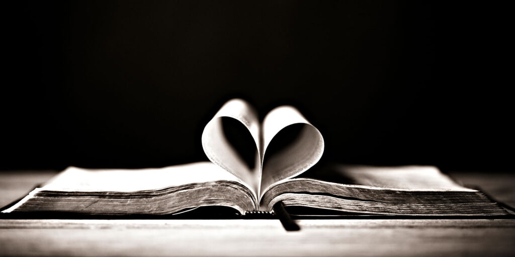 An open Bible with pages shaped like a heart.