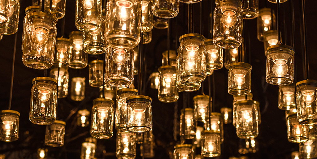 A bunch of lightbulbs hanging from a dark ceiling.