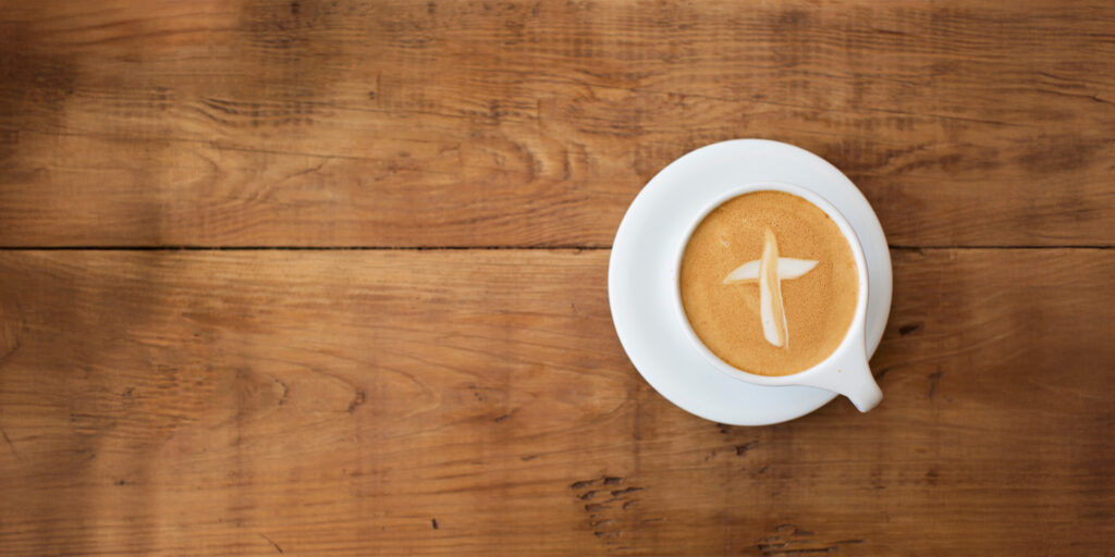 Coffee cup with cross shape creamer in cup.