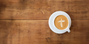 Coffee cup with cross shape creamer in cup.