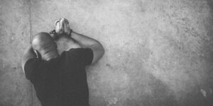 Man laying on grown praying