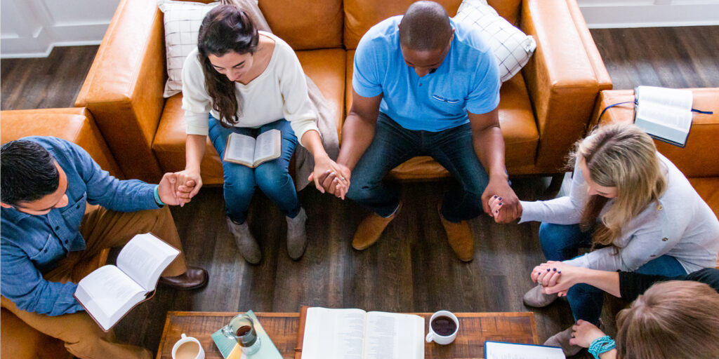 A group of adults praying together.