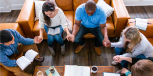 A group of adults praying together.